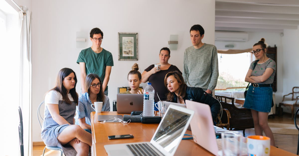 Equipe discutindo estratégias e analisando dados em reunião com laptop