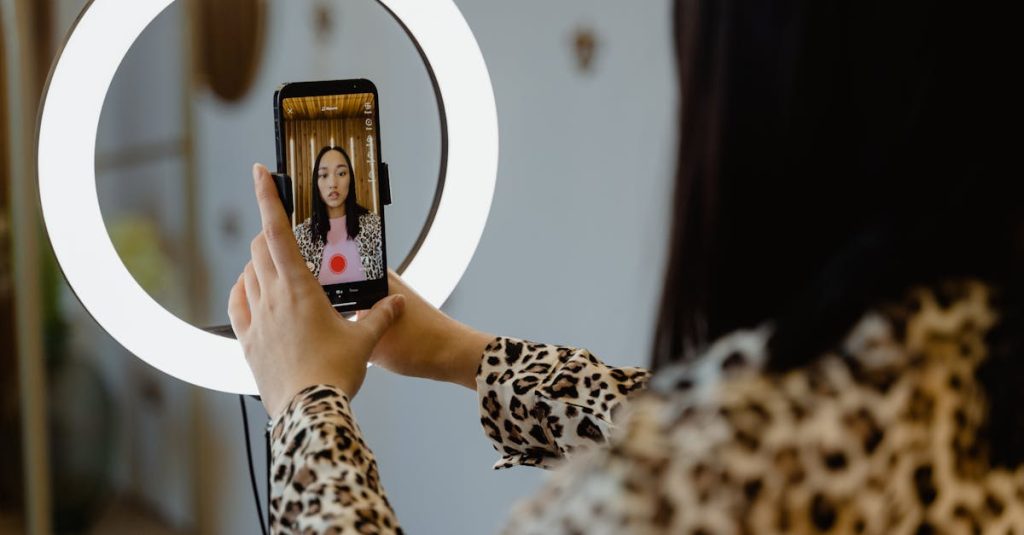 Pessoa segurando smartphone com gráficos e ícones de redes sociais na tela