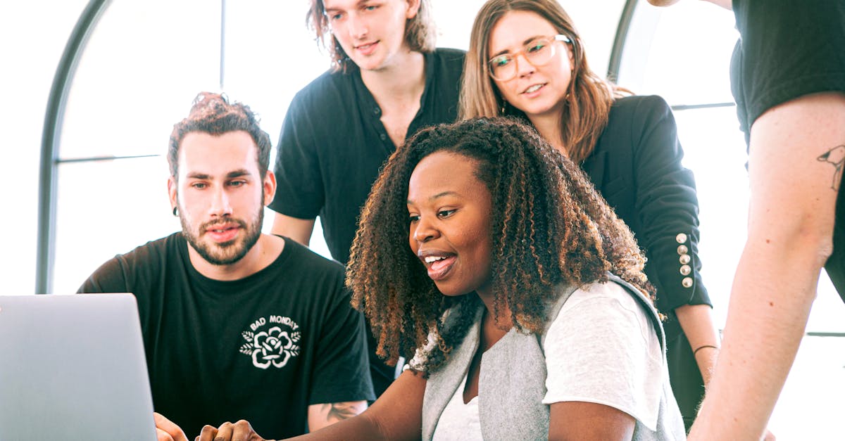 Equipe colaborando e usando laptops para planejamento de estratégias digitais