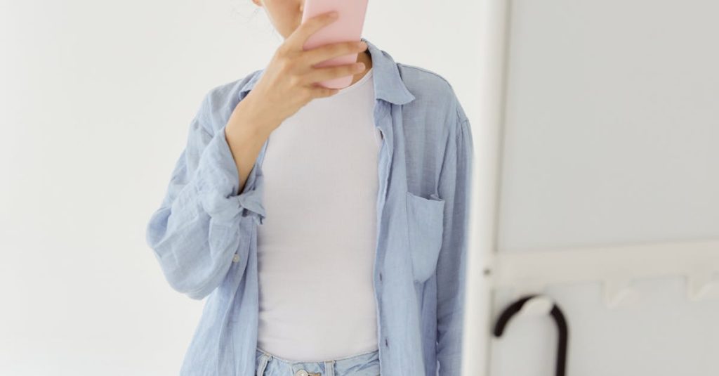 Microinfluenciador preocupado olhando o celular refletindo perda de seguidores no TikTok