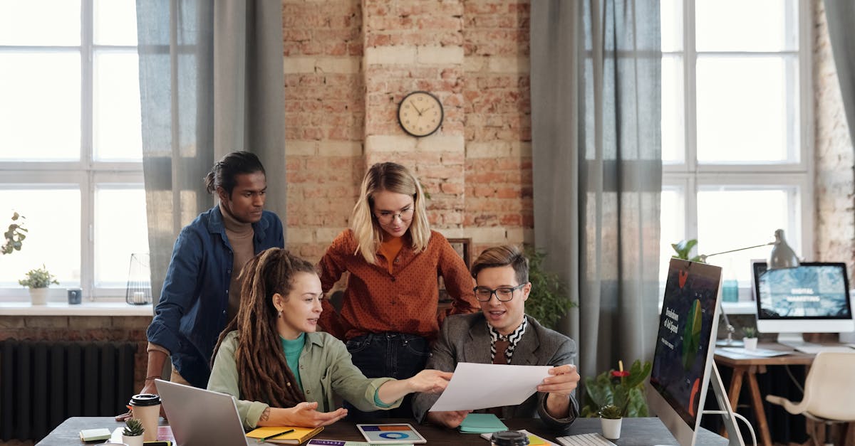 Equipe discutindo estratégias de marketing digital com computadores e anotações