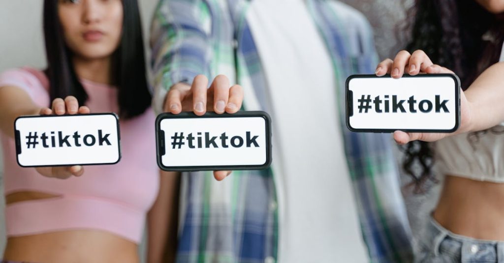 Mão segurando celular mostrando app do TikTok com gráficos de engajamento